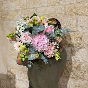 Magnifique création qui associe des hortensias, des roses poudrées et des touches d'eucalyptus.
