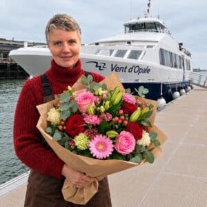 De retour du large à Boulogne-sur-Mer, un bouquet coloré de roses, de gerberas et de lys, enveloppé de kraft, évoque la fraîcheur des embruns et le charme du littoral.